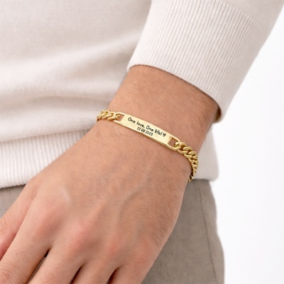 Pulseira dourada com placa gravada usada no pulso.