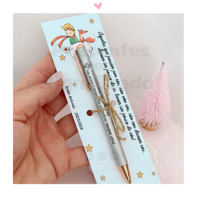 Caneta personalizada apresentada num cartão azul claro com ilustração de O Pequeno Príncipe e texto em português