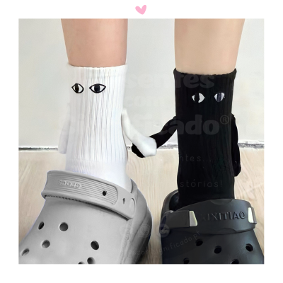 Meias brancas e pretas com padrão de olhos e dedos extras usadas com crocs cinza e preto