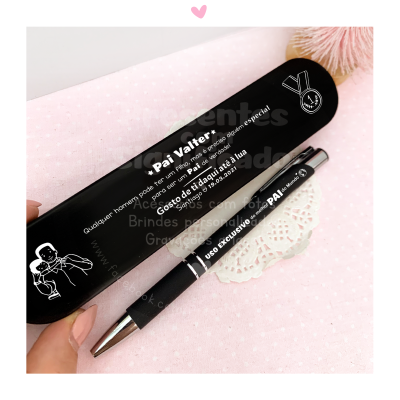 Estojo e caneta pretos personalizados com texto em português e fundo rosa com padrão de bolinhas