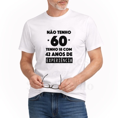 Homem de camisa branca com texto impresso em preto e calças de ganga, segurando óculos.