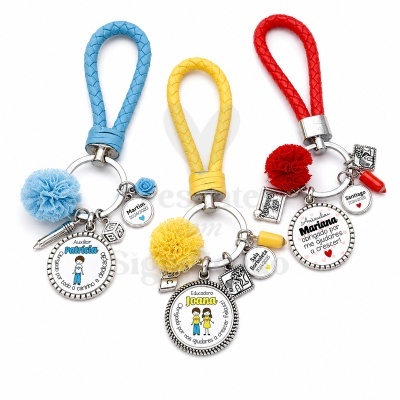 Três porta-chaves coloridos com pompom e placas personalizadas em português