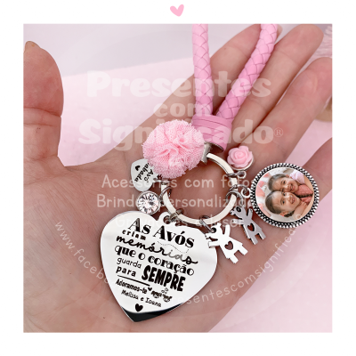 Chaveiro com pendentes e cordão rosa trançado numa mão