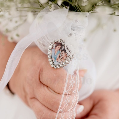 Ramo de flores com fita branca e medalha de coração com foto