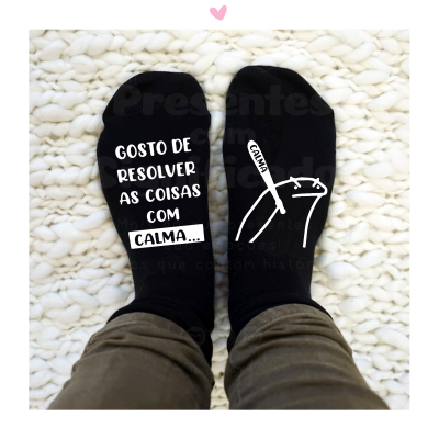 Meias pretas com texto branco, uma com mensagem, outra com desenho de rato e palavra CALMA