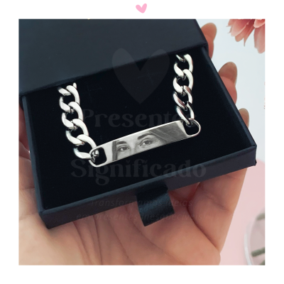 Pulseira prateada com placa retangular numa caixa preta