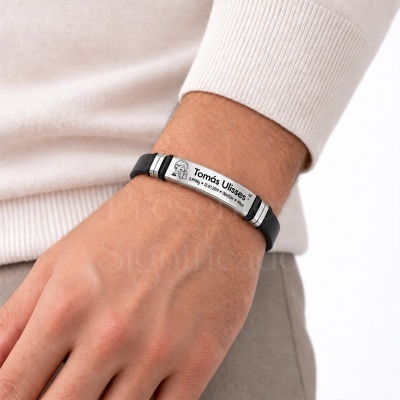 Pulseira de couro preta com placa metálica gravada no pulso de uma pessoa