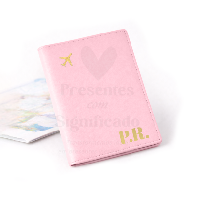 Capa de passaporte rosa com avião dourado e iniciais P.R.