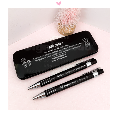 Este conjunto inclui estojo preto e duas canetas metálicas pretas com textos brancos comemorativos para avô e avó.