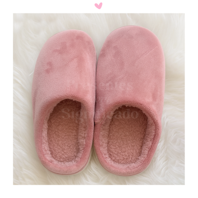 Chinelos cor-de-rosa com interior forrado a pelo sobre fundo branco felpudo