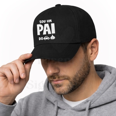 Boné preto com texto branco e desenhos usados por homem com hoodie cinzento