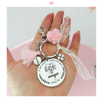 Porta-chaves redondo branco com texto, pendurais rosa, renda branca e pompom na mão
