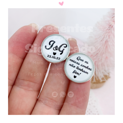 Dois botões metálicos redondos com textos em português e fundo branco