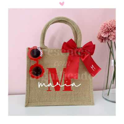 Saco de mão em ráfia com alças, laço vermelho e óculos de sol vermelhos