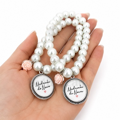 Duas pulseiras de pérolas brancas com pendentes de texto e rosas cor de rosa