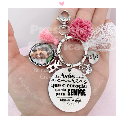 Porta-chaves com foto redonda, pompons rosa e branco, pendentes metálicos e texto sentimental em português
