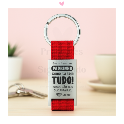 Porta-chaves com fita vermelha e peça metálica com texto gravado