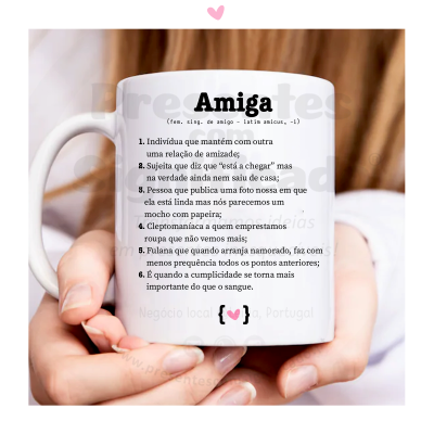 Caneca branca com texto em português sobre a palavra 'Amiga' e sua definição, segurada por mãos.
