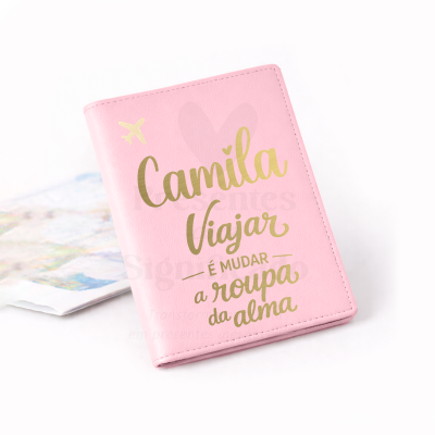 Capa de passaporte rosa com texto em dourado e ilustração de avião e coração