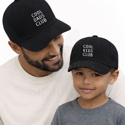 Homem e criança com bonés pretos com texto branco.
