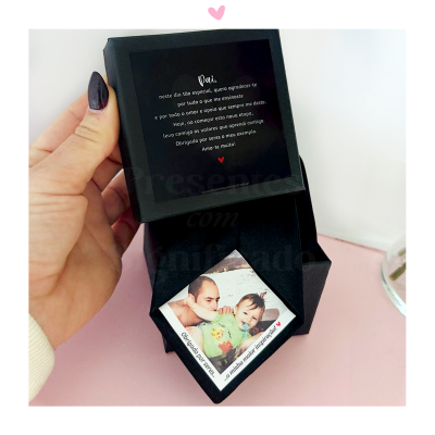 Caixa preta com carta e fotografia de homem e criança