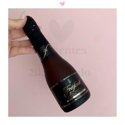 Garrafa pequena de champanhe Freixenet Cordon Negro Dry Cava em fundo rosa