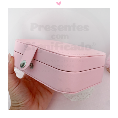 Estojo quadrado rosa com fecho prateado em mão feminina