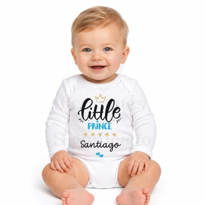 Bebé loiro com body branco e texto little PRINCE Santiago sentado em fundo branco.