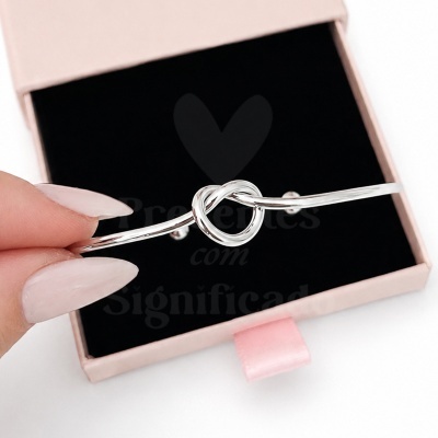 Pulseira prateada com nó em caixa rosa com interior preto