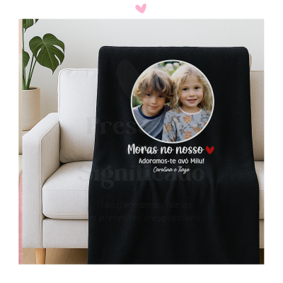 Manta preta personalizada com foto de duas crianças e texto em português sobre um sofá branco