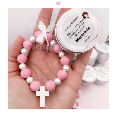 Pulseira de contas rosa e brancas com cruz e embalagem redonda com agradecimento de batismo