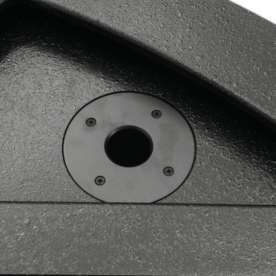 Parte de estrutura preta com buraco circular central e parafusos