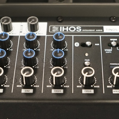 mesa de som preta com botões e ajustes diversos