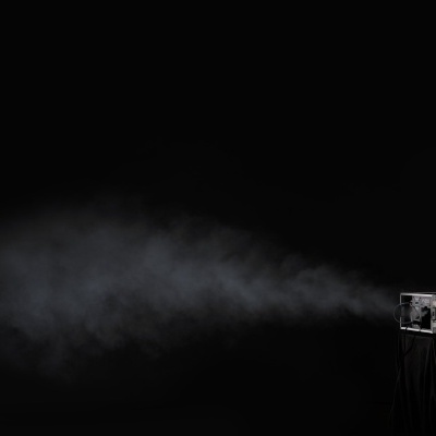 Máquina de fumo metálica a emitir fumo contra fundo negro