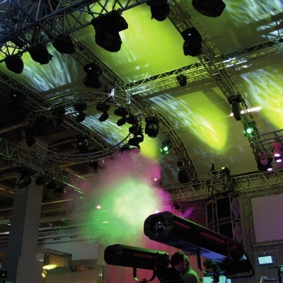 Equipamentos de iluminação profissional com luzes coloridas e estruturas metálicas num espaço interior.