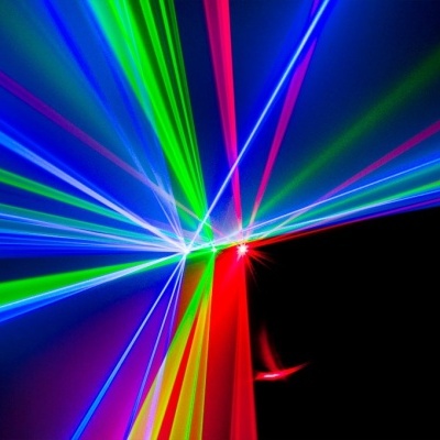 Feixes de luzes coloridas cruzando-se num fundo escuro