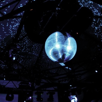 Bola de discoteca azul luminosa suspensa no teto escuro