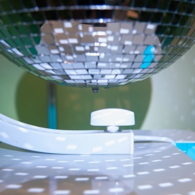 Espelho de discoteca refletindo luz sobre superfície branca