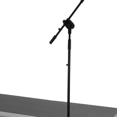 Microfone preto num suporte de tripé ajustável em mesa preta com borda prateada.