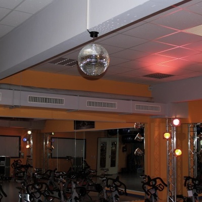 Ginásio com bicicletas estáticas e bola de discoteca suspensa no teto