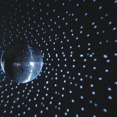 Espelho de discoteca espelhado refletindo luzes num padrão em parede escura