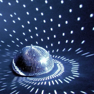 Disco espelhado pequeno refletindo luz em superfície escura