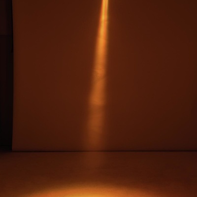 Projetor de luz amarela no teto iluminando o chão