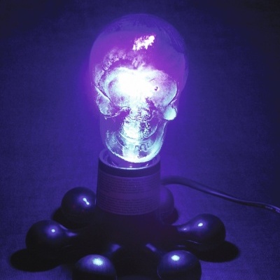 Lanterna decorativa em formato de crânio iluminado azul com base preta e bolas pretas ao redor