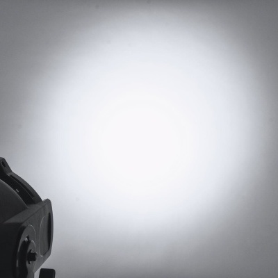 Equipamento óptico preto com feixe de luz branco projectado numa parede