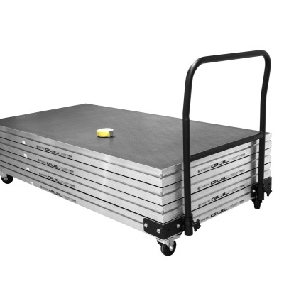 Tábua empilhada com estrutura metálica, rodas e punho, fita métrica sobre a tábua.