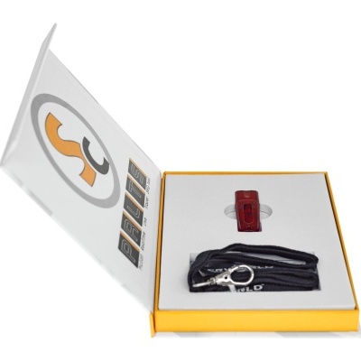 Conjunto eletrónico vermelho e cabos pretos em embalagem amarela aberta