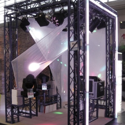 Estrutura metálica preta com iluminação de palco e painel translúcido