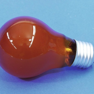 Lâmpada incandescente de vidro âmbar sobre fundo azul