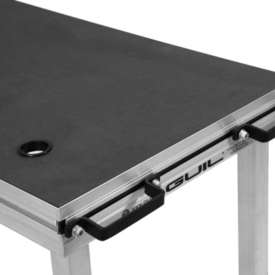 Mesa quadrada com tampo preto e estrutura metálica prateada com puxadores pretos e texto GUIL